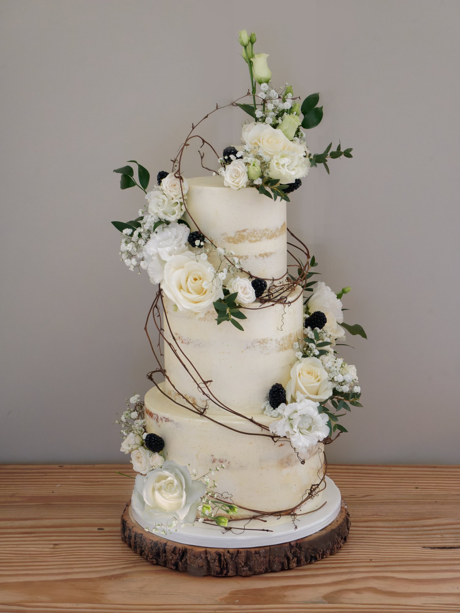 Semi-naked wedding cake with vines and blackberries.
Wedding cake with roses
Wedding cake